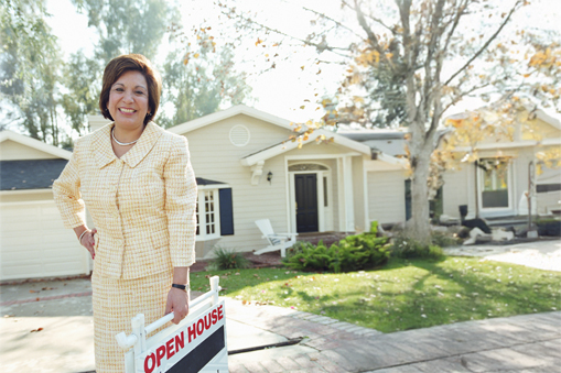 realtor lady holding open house sign in front of house
