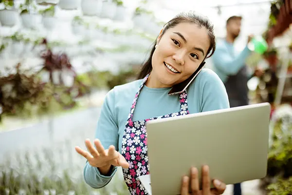 gardener receiving business help through phone and laptop